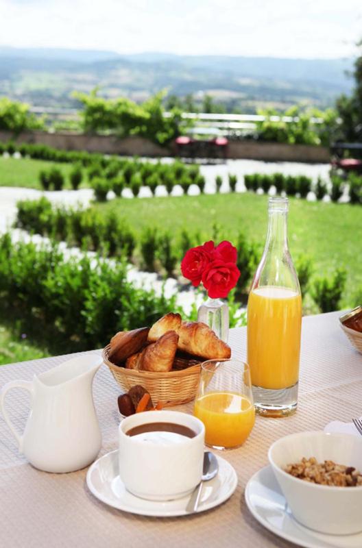 une table avec un petit-déjeuner composé de pain et de jus d'orange dans l'établissement Domaine Saint-Roch Hotel Spa, à Salzuit 22 autres photos