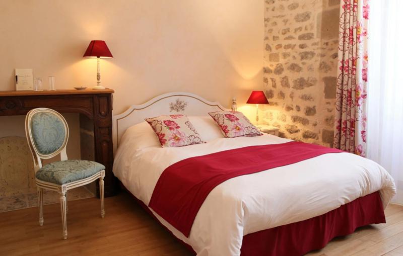 une chambre avec un lit, une chaise et un bureau dans l'établissement Domaine Saint-Roch Hotel Spa, à Salzuit