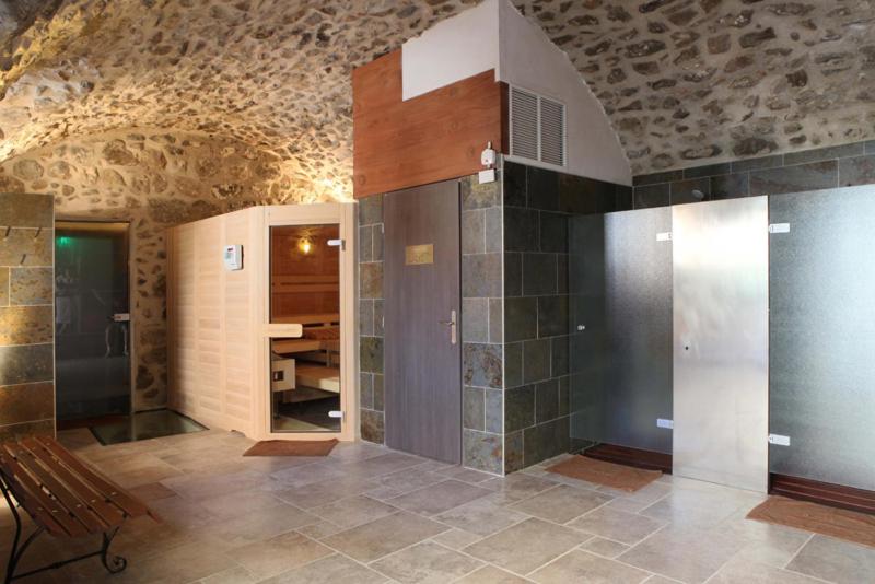 Cette chambre comprend une salle de bains avec un banc et une table. dans l'établissement Domaine Saint-Roch Hotel Spa, à Salzuit