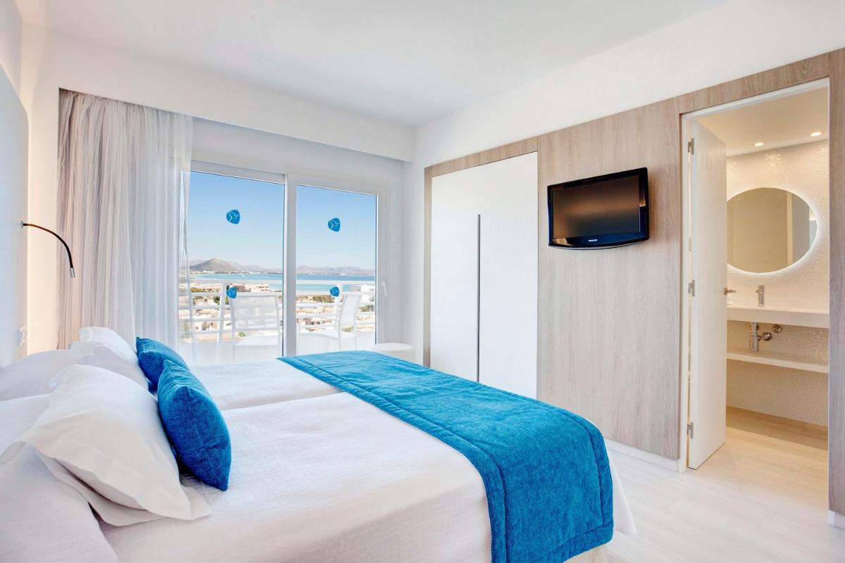 1 dormitorio con 1 cama grande y TV en la pared en Grupotel Farrutx, en Can Picafort