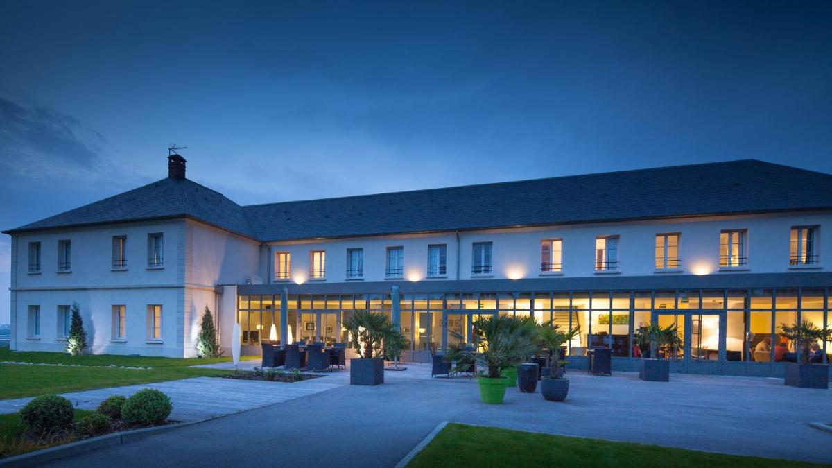 un grand bâtiment blanc avec beaucoup de fenêtres dans l'établissement Hôtel - Spa Les Corderies, à Saint-Valery-sur-Somme