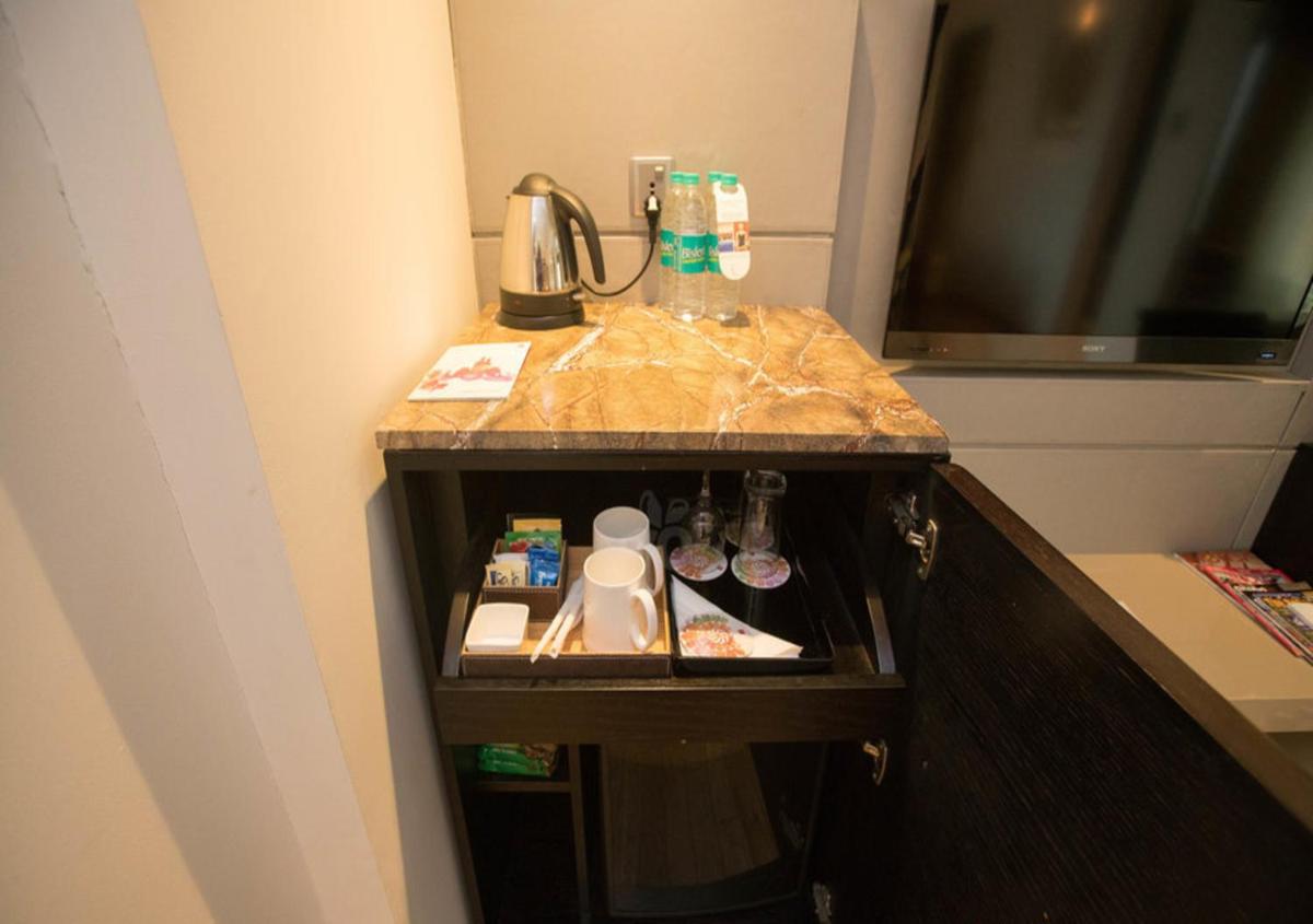 a bathroom counter with a sink and a coffee maker on it at The LaLiT New Delhi in New Delhi