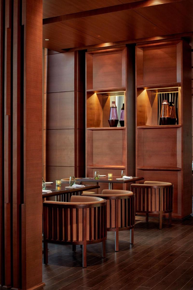 a restaurant with brown chairs and tables and shelves at Hyatt Regency Chandigarh in Chandīgarh