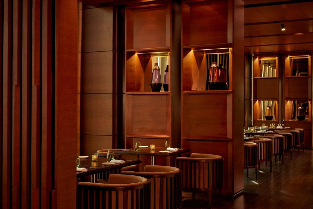 a restaurant with a row of tables and stools at Hyatt Regency Chandigarh in Chandīgarh