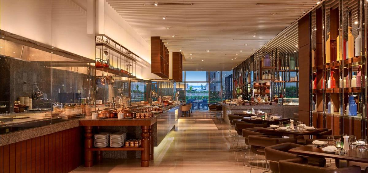 a restaurant with tables and chairs and a bar at Hyatt Regency Chandigarh in Chandīgarh