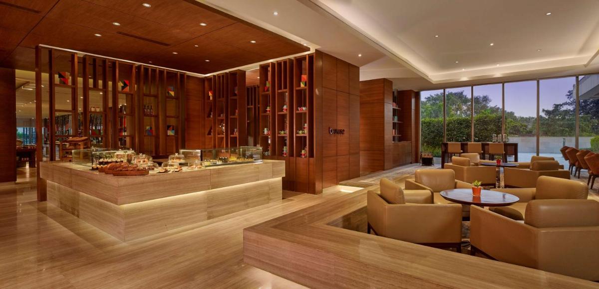 a restaurant with a bar with chairs and a table at Hyatt Regency Chandigarh in Chandīgarh