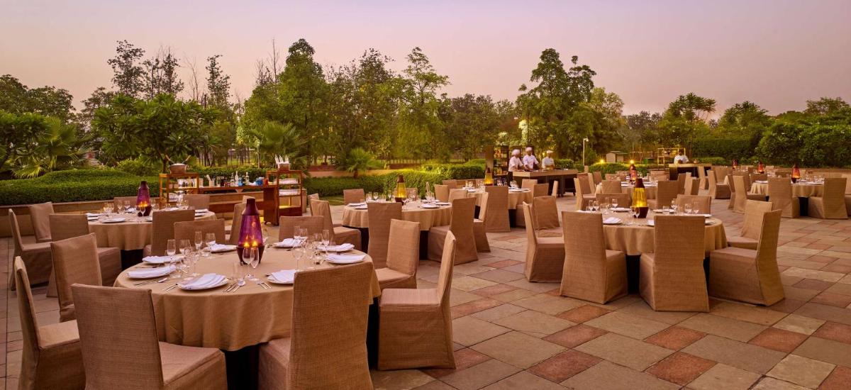 a restaurant with tables and chairs and people in the background at Hyatt Regency Chandigarh in Chandīgarh