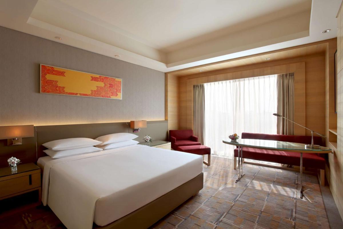 a bedroom with a large white bed and a desk at Hyatt Regency Chandigarh in Chandīgarh