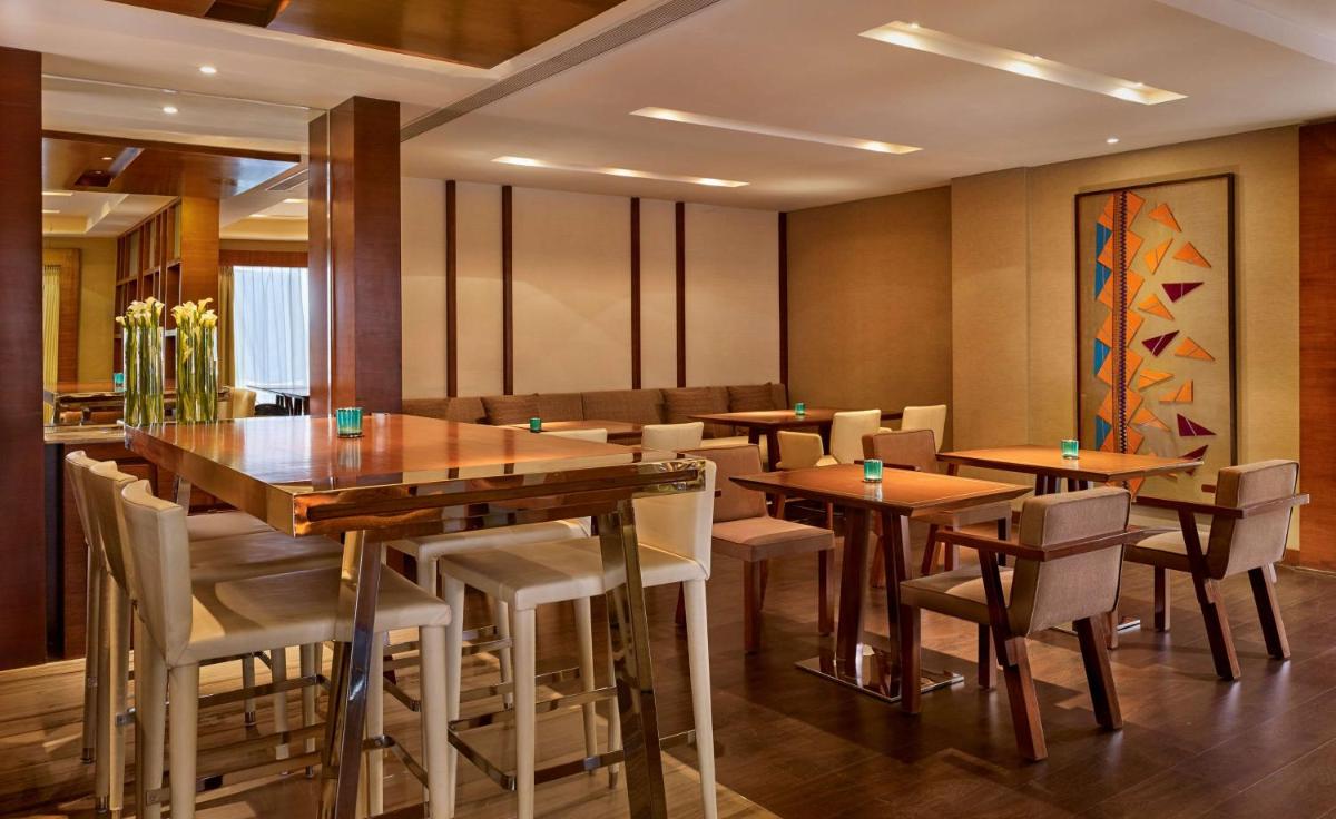 a dining room with wooden tables and chairs at Hyatt Regency Chandigarh in Chandīgarh