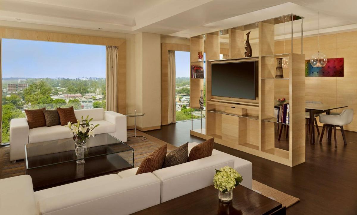 a living room with a white couch and a tv at Hyatt Regency Chandigarh in Chandīgarh