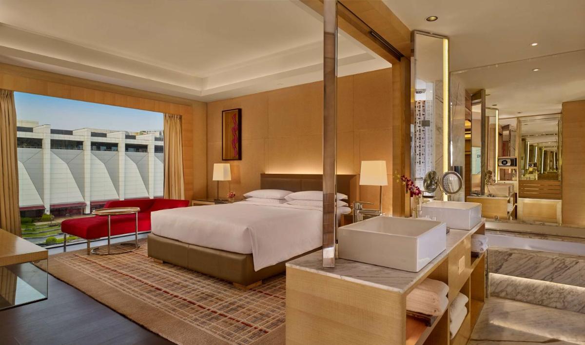 a bedroom with a large bed and a bathroom at Hyatt Regency Chandigarh in Chandīgarh