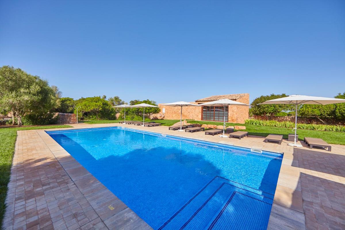 una piscina con sillas y sombrillas en Bennoc Petit Hotel - Only Adults, en Llucmajor