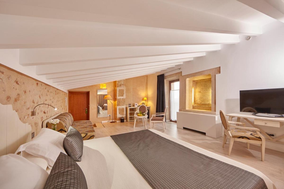 Un dormitorio con una cama y una sala de estar. en Bennoc Petit Hotel - Only Adults, en Llucmajor