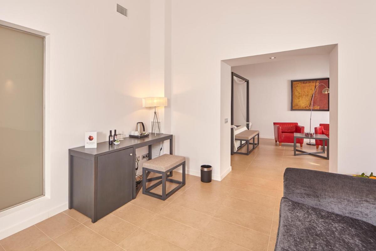 Una sala de estar con un sofá, una mesa y sillas. en Bennoc Petit Hotel - Only Adults, en Llucmajor