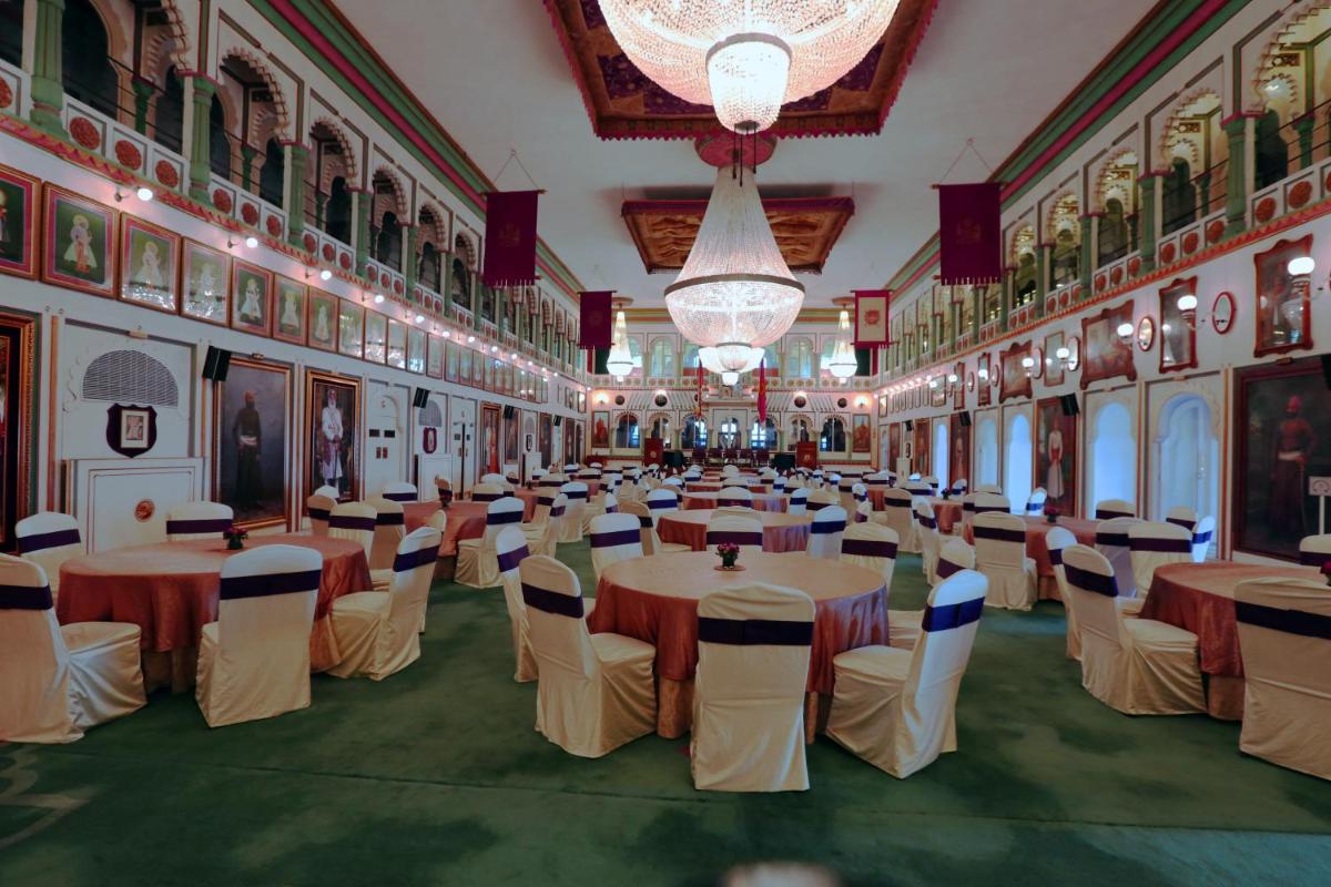 a banquet hall with tables and chairs and chandeliers at Taj Fateh Prakash Palace Udaipur in Udaipur