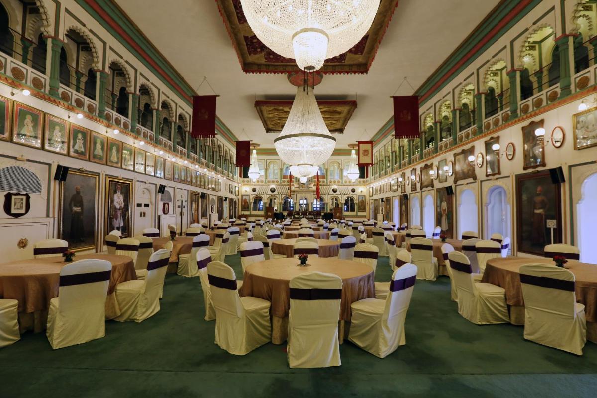 a banquet hall with tables and chairs in a building at Taj Fateh Prakash Palace Udaipur in Udaipur
