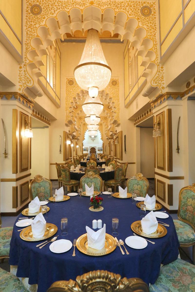 a dining room with a blue table with plates and napkins at Taj Fateh Prakash Palace Udaipur in Udaipur
