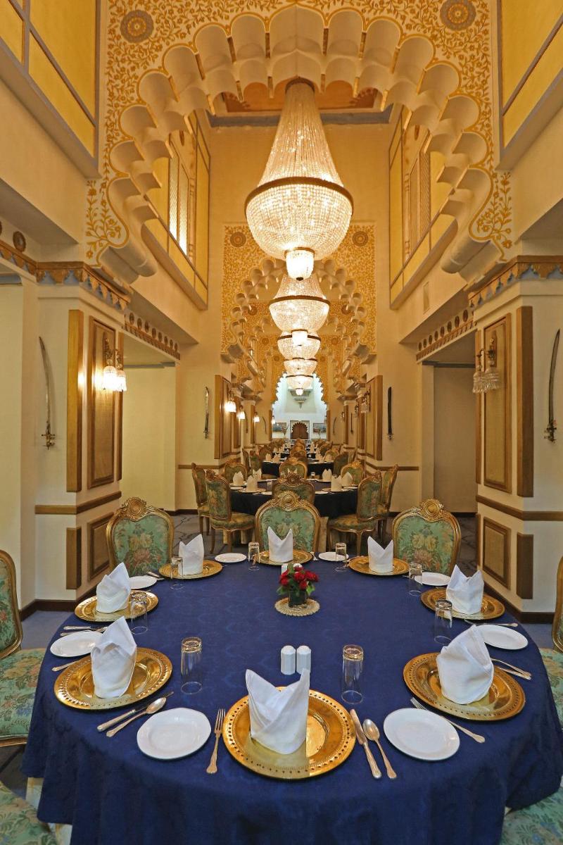 a dining room with a blue table with plates and napkins at Taj Fateh Prakash Palace Udaipur in Udaipur