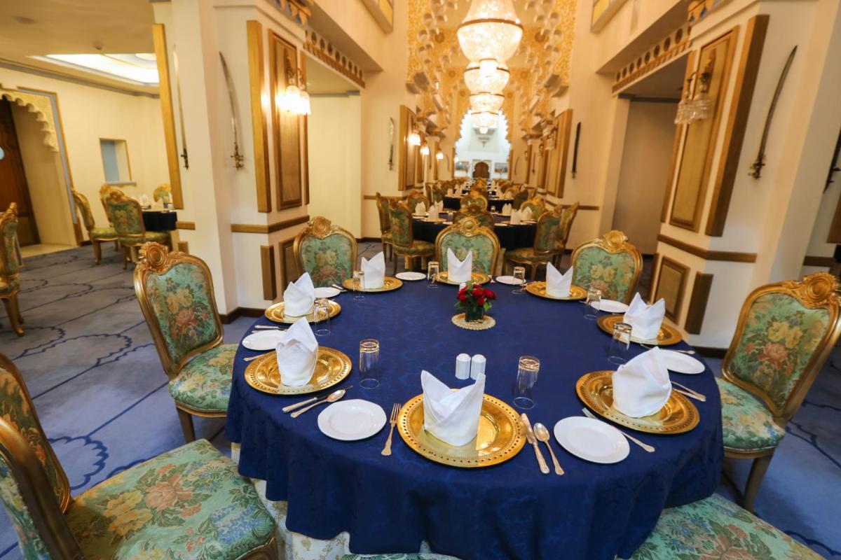 a dining room with a blue table and chairs at Taj Fateh Prakash Palace Udaipur in Udaipur