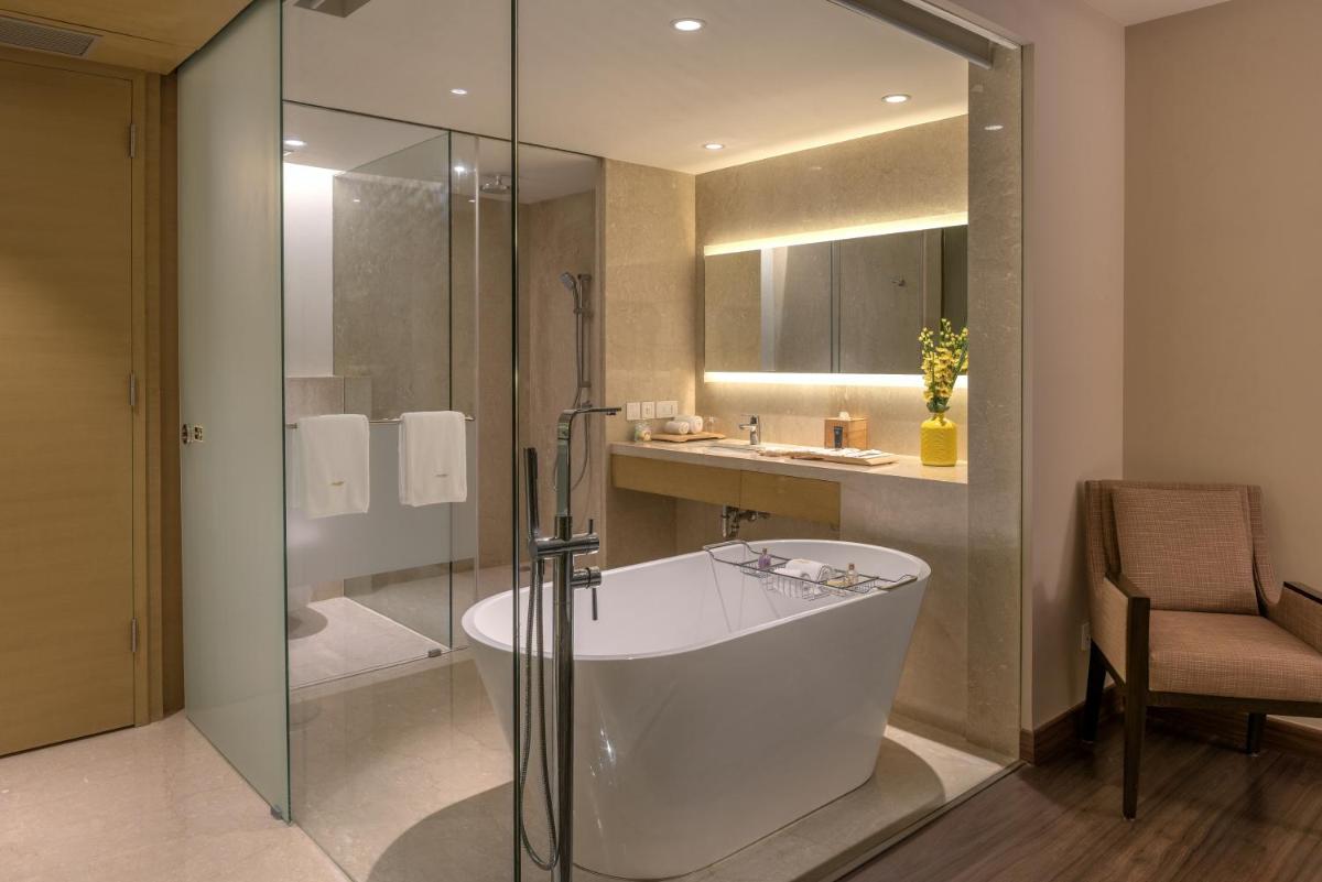 a bathroom with a tub and a shower and a sink at Feathers- A Radha Hotel, Chennai in Chennai