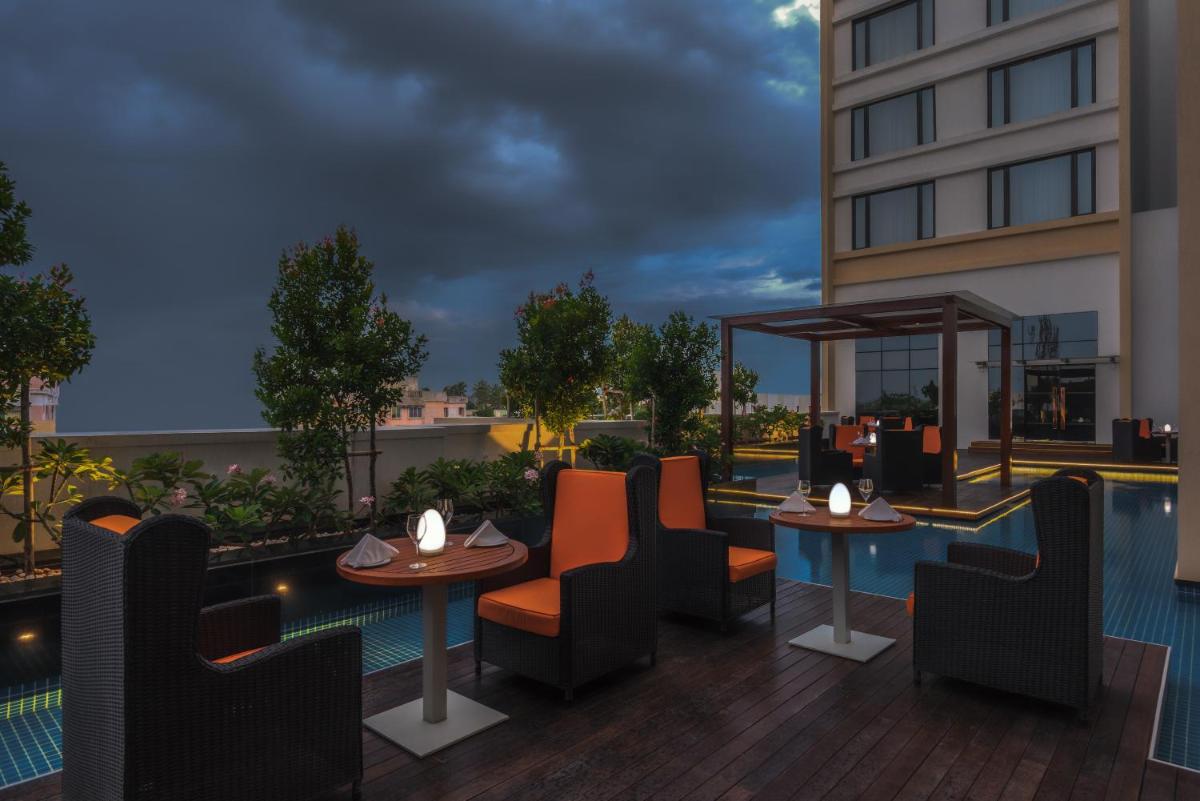 an image of a rooftop patio with tables and chairs at Feathers- A Radha Hotel, Chennai in Chennai