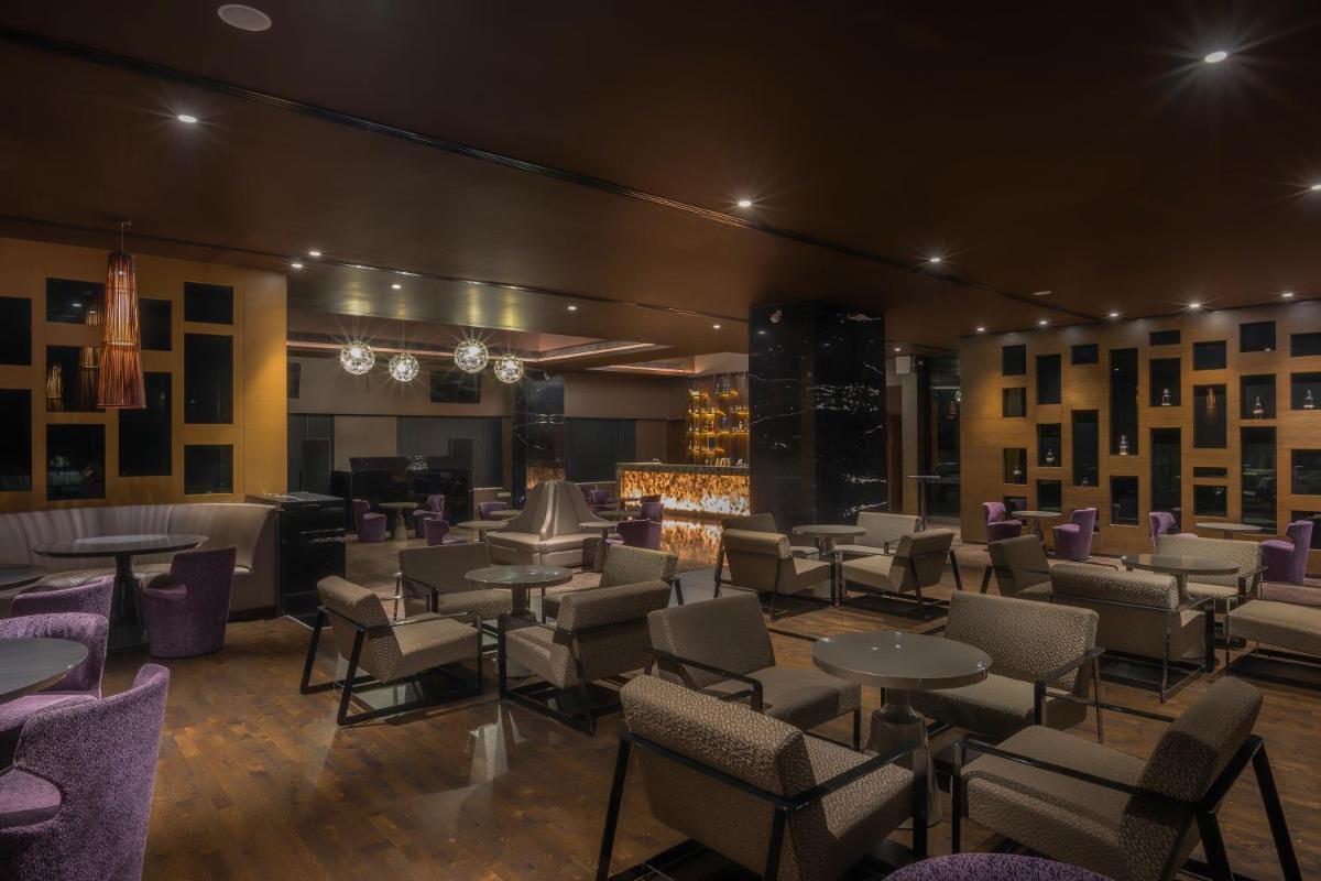 a restaurant with tables and chairs and a fireplace at Feathers- A Radha Hotel, Chennai in Chennai