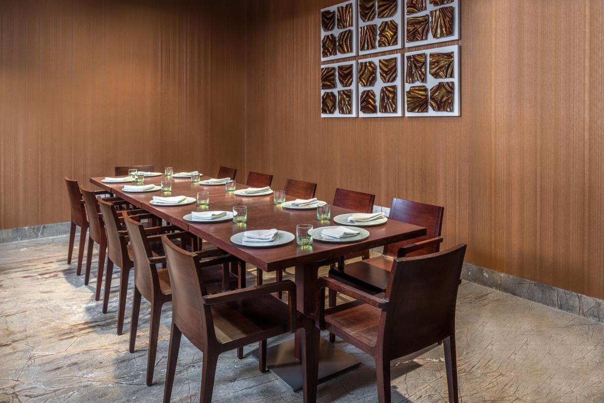 a long wooden table and chairs in a room at Feathers- A Radha Hotel, Chennai in Chennai