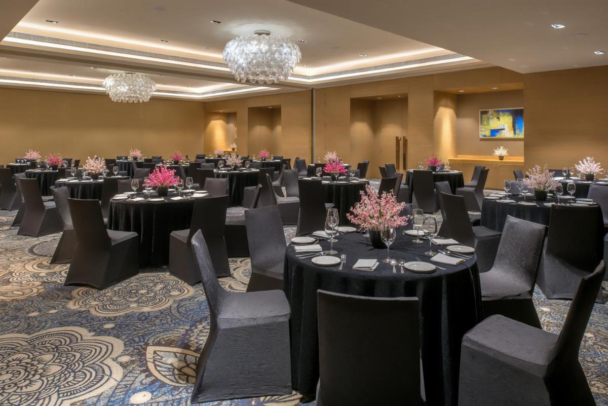 a ballroom with tables and chairs in a room at Feathers- A Radha Hotel, Chennai in Chennai