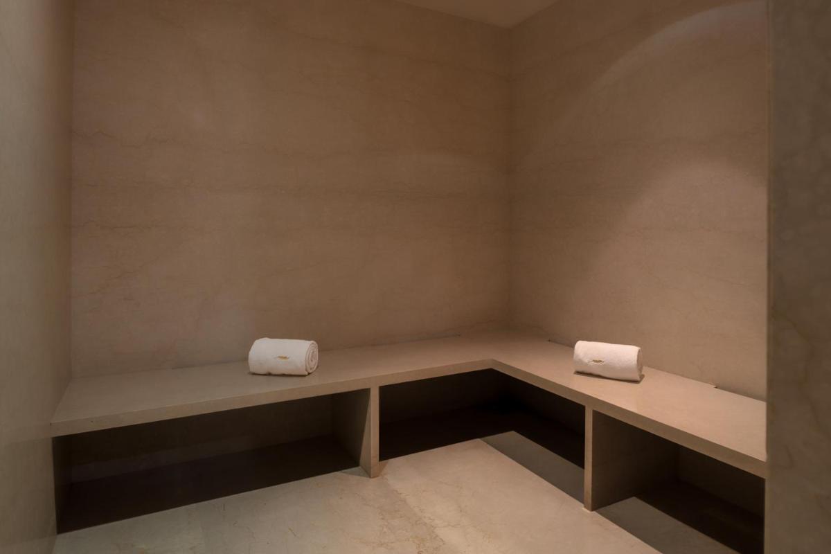 two white towels sitting on a bench in a room at Feathers- A Radha Hotel, Chennai in Chennai