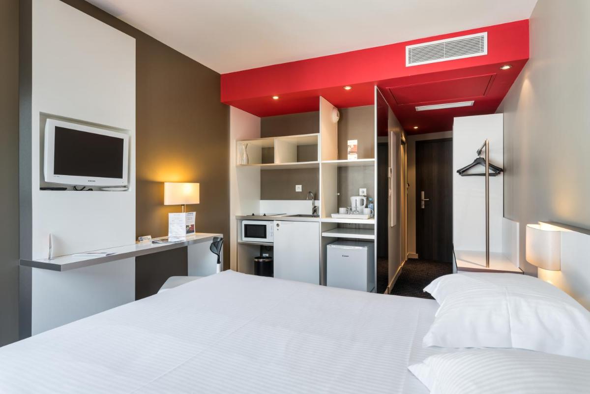 une chambre avec un lit blanc et un plafond rouge dans l'établissement B&B HOME Lyon Centre Berthelot, à Lyon
