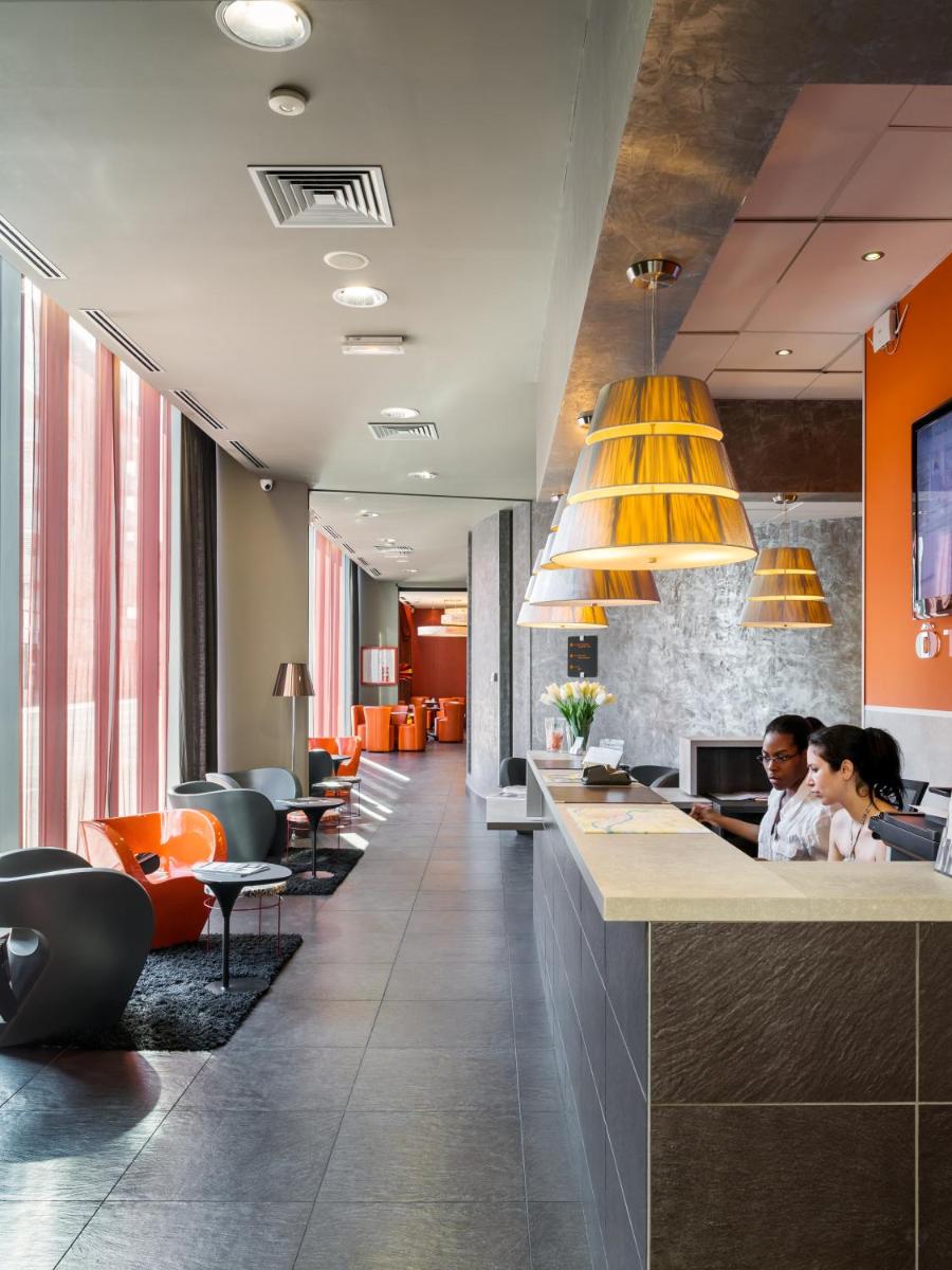 un hall avec deux personnes assises à un bar dans l'établissement B&B HOME Lyon Centre Berthelot, à Lyon