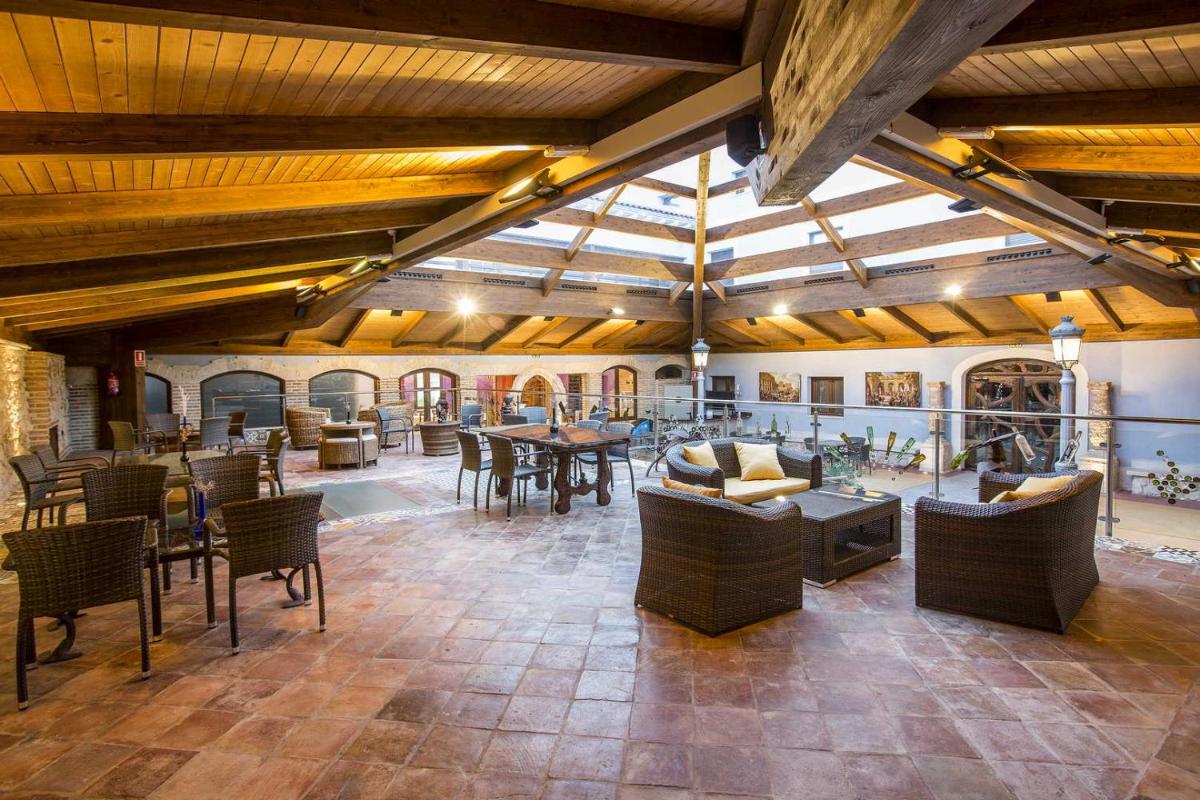 Una gran sala con mesas y sillas en un edificio. en Hotel SPA El Lagar de Isilla, en La Vid y Barrios