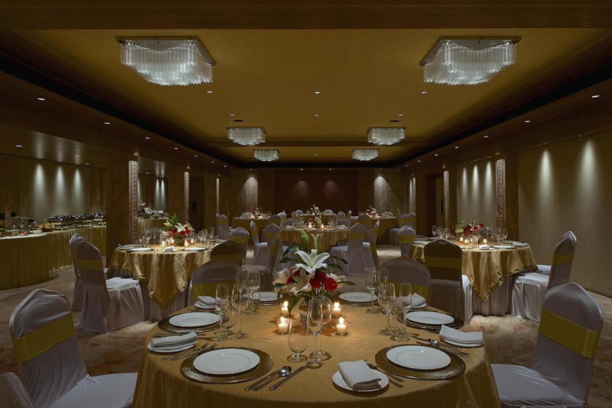 a banquet room with tables and chairs and tablesktop at Hotel Lakend in Udaipur