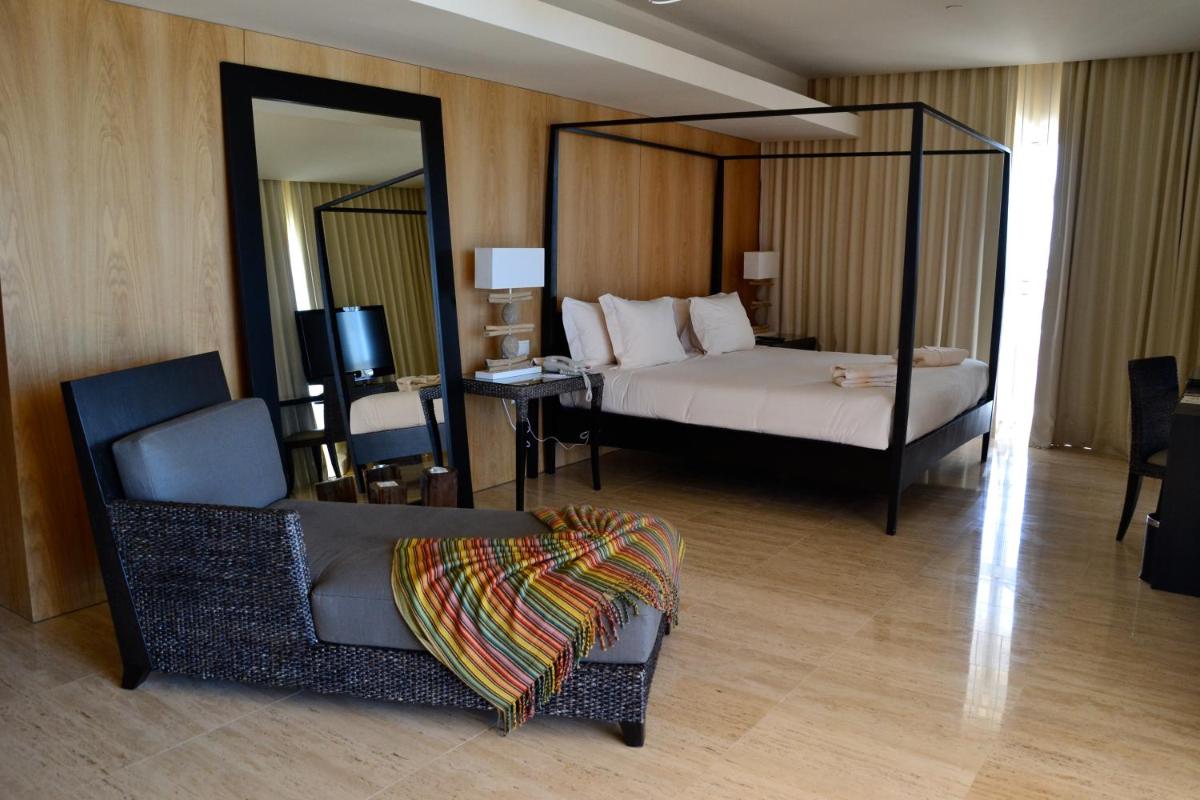 um quarto com uma cama, uma cadeira e um espelho em Crowne Plaza Vilamoura - Algarve by IHG em Vilamoura mais 117 fotografias