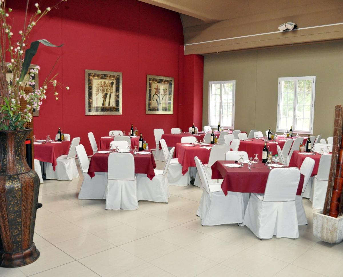 un comedor con mesas blancas y paredes rojas en Balneario de Cofrentes, en Cofrentes
