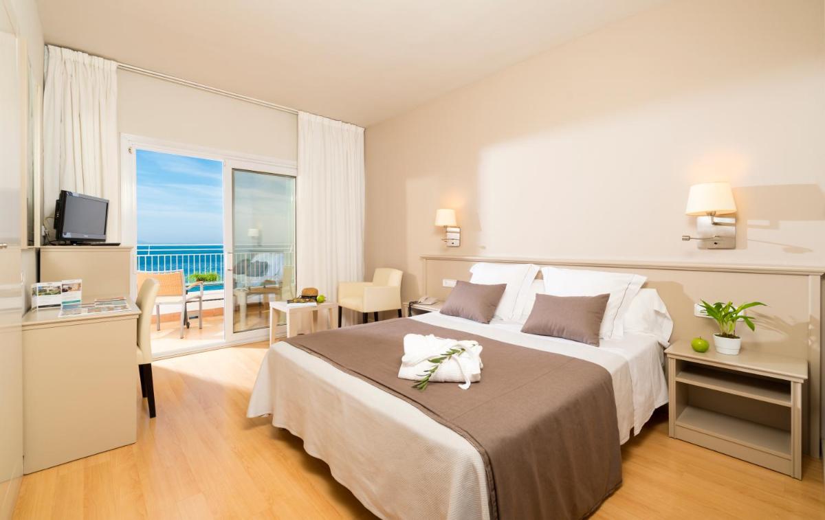 Un dormitorio con una cama grande con vista al mar. en Hotel & Spa Terraza 4 Sup, en Roses Un dormitorio con una cama grande con vista al mar. en Hotel & Spa Terraza 4 Sup, en Roses