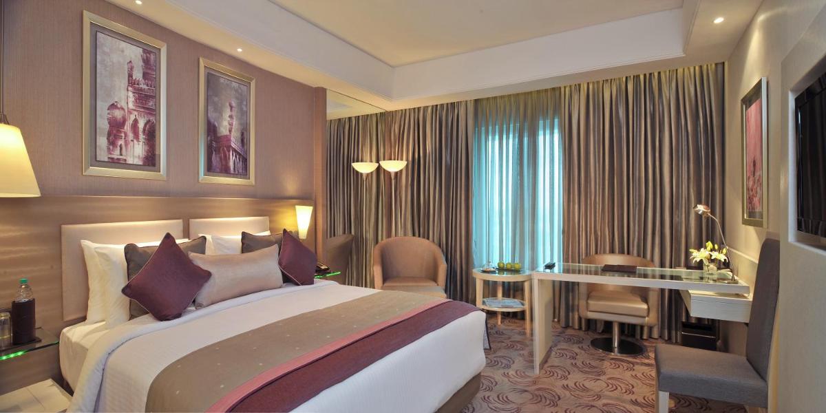 a hotel room with a large bed and a desk at Radisson Hyderabad Hitec City in Hyderabad