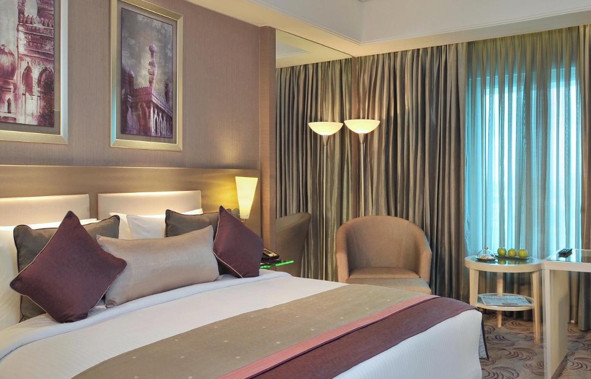 a hotel room with a bed and a chair at Radisson Hyderabad Hitec City in Hyderabad