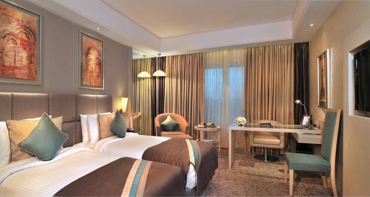 a hotel room with a bed and a desk at Radisson Hyderabad Hitec City in Hyderabad