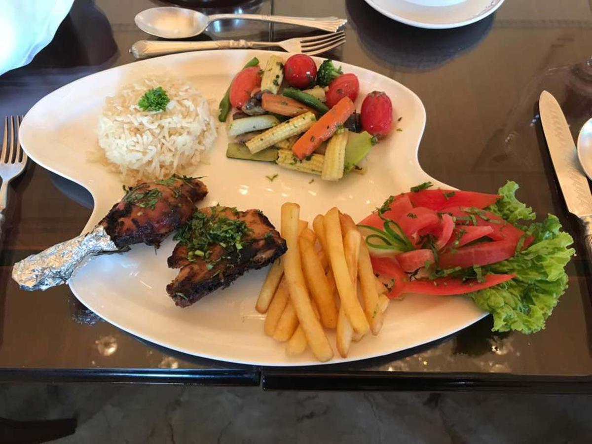 a plate of food with rice and meat and french fries at The Raj Palace (Small Luxury Hotels of the World) in Jaipur