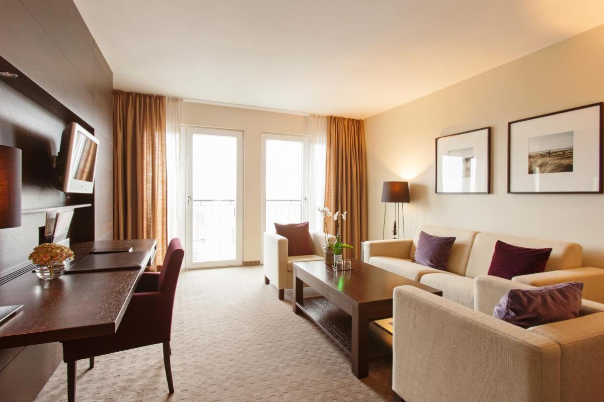 ein Wohnzimmer mit Sofa und Tisch in der Unterkunft A-ROSA Sylt in List