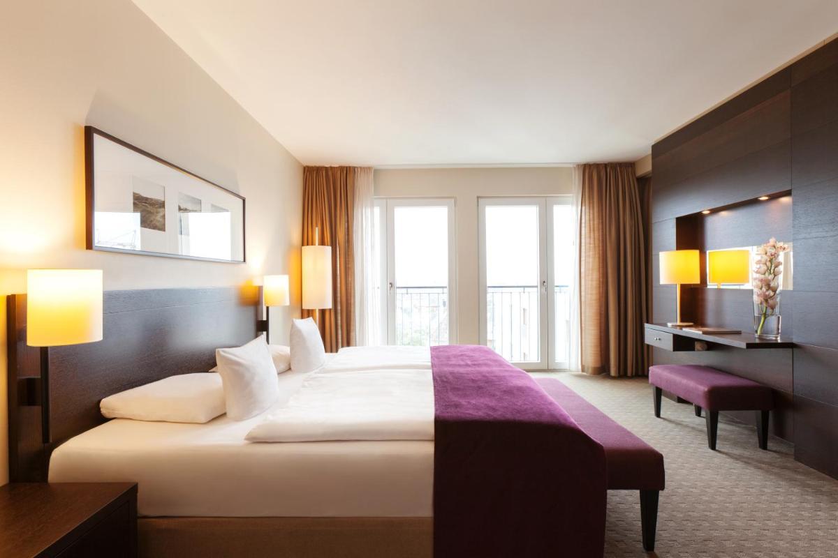 ein Hotelzimmer mit einem großen Bett und einem Fenster in der Unterkunft A-ROSA Sylt in List