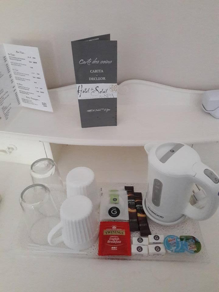 un comptoir blanc avec quelques articles sur une étagère dans l'établissement Hotel du Soleil et Spa, à Saint-Rémy-de-Provence