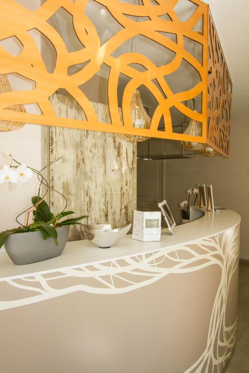 un lustre orange accroché au-dessus d'un comptoir blanc dans l'établissement Hotel du Soleil et Spa, à Saint-Rémy-de-Provence