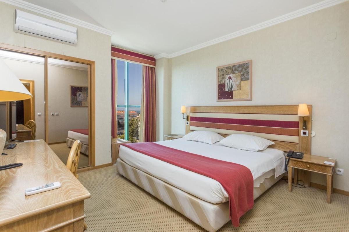 um quarto de hotel com uma cama grande e uma escrivaninha em Riviera Hotel em Carcavelos