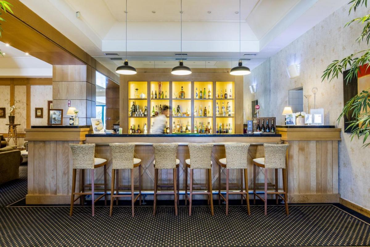 um bar em um restaurante com bancos em Riviera Hotel em Carcavelos