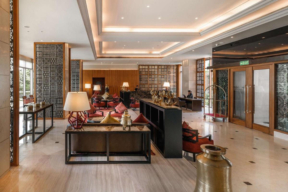 a lobby of a hotel with a table and chairs at Hyatt Ahmedabad in Ahmedabad