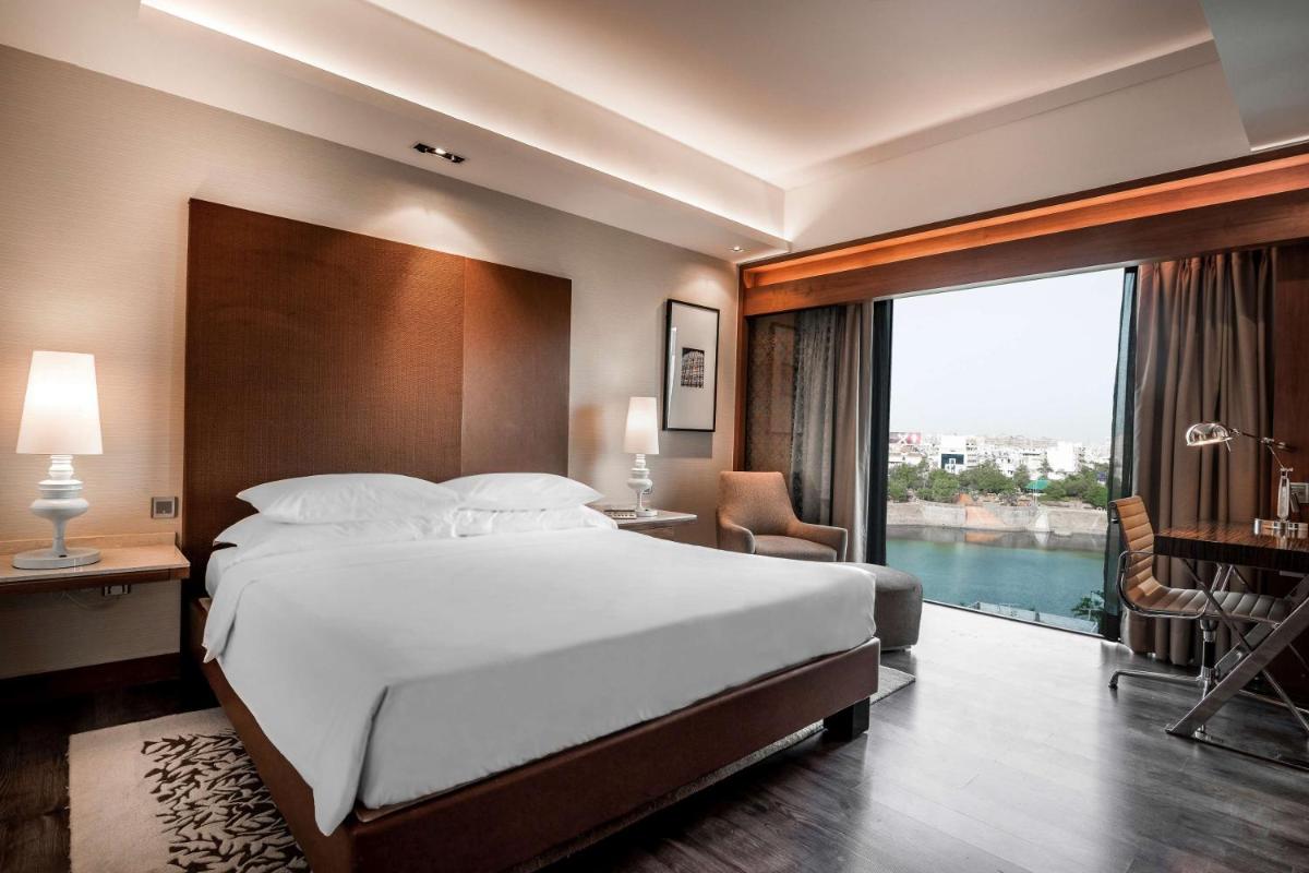 a bedroom with a large bed and a large window at Hyatt Ahmedabad in Ahmedabad