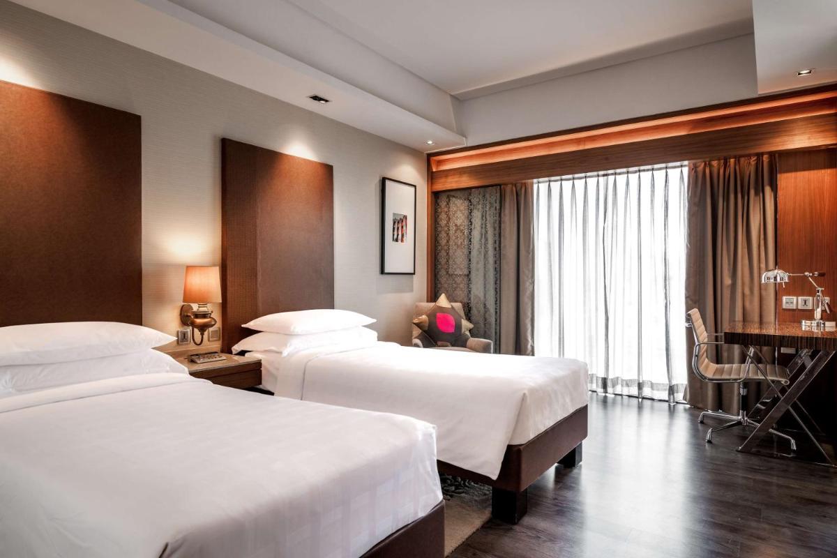 a hotel room with two beds and a piano at Hyatt Ahmedabad in Ahmedabad
