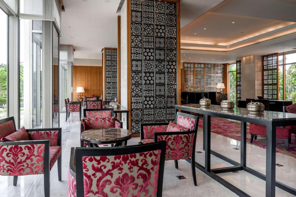 a restaurant with red chairs and a table in a room at Hyatt Ahmedabad in Ahmedabad